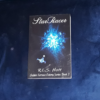 A paperback copy of StarRacer. On the cover, a crystalline blue spaceship heads toward an explosion of blue light. Text: "StarRacer; R. L. S. Hoff; Golden Terrace Colony Series Book 2"