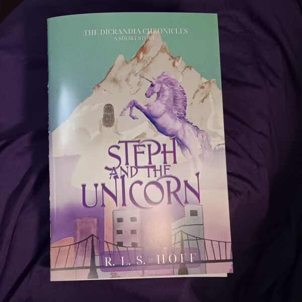 A glossy bound zine copy of Steph and the Unicorn sits on a purple background.